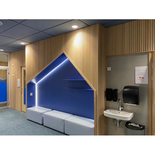 Sein&auml;&auml;n upotettu moderni istumatila, joka on sisustettu l&auml;mpimill&auml; v&auml;reill&auml; ja pehmeill&auml; materiaaleilla luomaan rahoittava tunnelma.