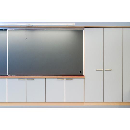 Moderni liitutaulu ja sen alapuolella sijaitsevat säilytyskaapit Länsikadun koulun luokkahuoneessa, yhdistäen käytännöllisyyden ja minimalistisen designin.