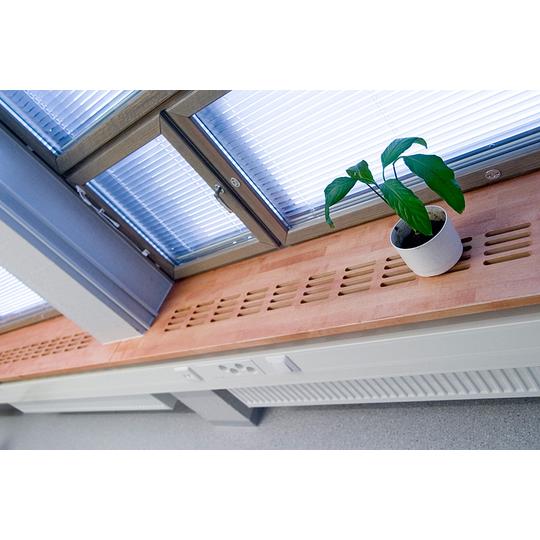 Puisen ikkunalaudan ilmanvaihtoaukot ja ruukkuvihre&auml; koristekasvi L&auml;nsikadun koulussa. Laadukkaasti toteutettu design yhdist&auml;&auml; toiminnallisuuden ja estetiikan.