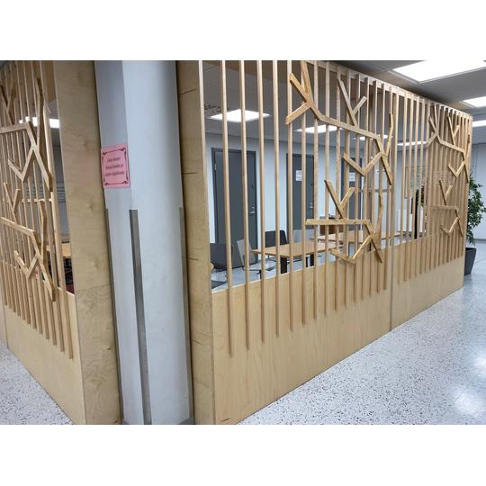 L&auml;nsikadun koulun tilanjakaja, joka on valmistettu puus&auml;leik&ouml;st&auml; ja koristeltu oksamaisilla yksityiskohdilla.