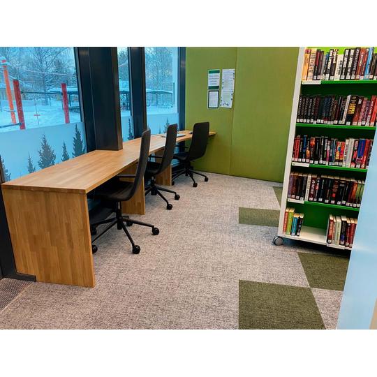 Karsikon kirjaston ty&ouml;skentelytila, jossa puupintaiset ty&ouml;p&ouml;yd&auml;t ja ergonomiset tuolit tarjoavat rauhallisen ymp&auml;rist&ouml;n lukemiseen ja opiskeluun.