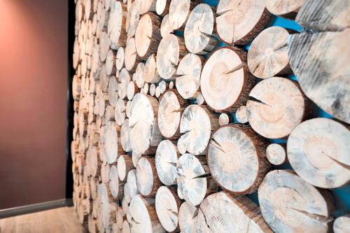 Lähikuva puupintaiselle seinäelementille, joka on osa Joen Erikoiskalusteiden toteuttamaa projektia. Seinä on valmistettu luonnonmateriaaleista ja se tuo tilan ilmeeseen lämpöä ja persoonallisuutta. Kuva: PKO.