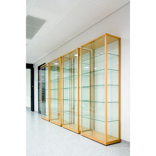 Rivissä seisovat lasivitriinit puukehyksillä Länsikadun koulun käytävällä. Tilavat vitriinit soveltuvat esineiden ja palkintojen esillepanoon oppimisympäristössä.