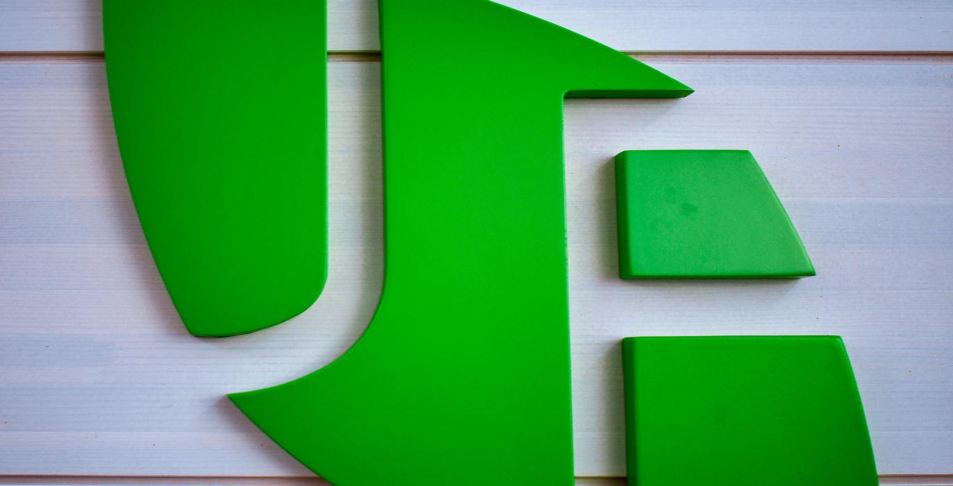 Joen Erikoiskalusteen vihre&auml; logo, joka on esill&auml; valkoista vaakapaneloitua taustaa vasten.