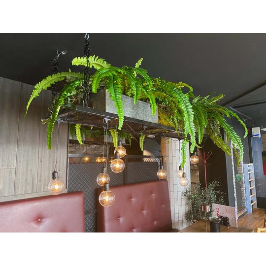 Viherkasviasetelmin koristeltu Joen Erikoiskalusteen asentama kattovalaisin Rosso Joensuussa.