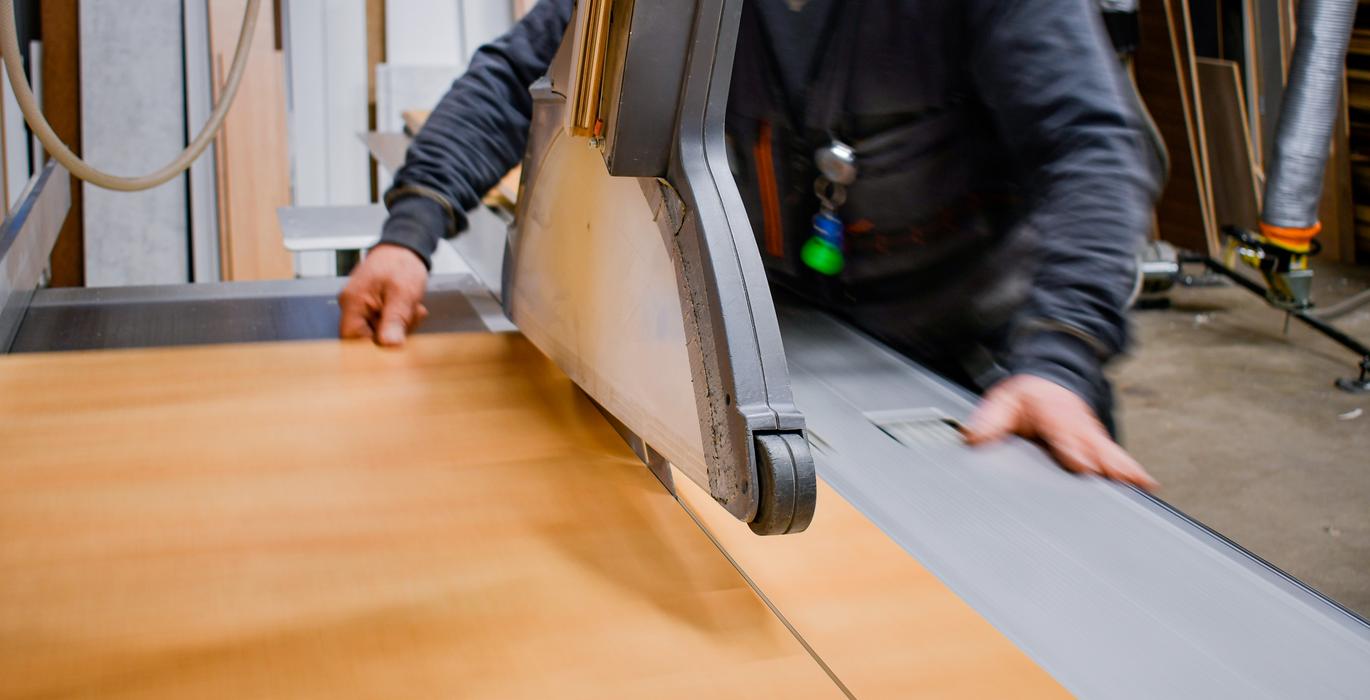 Ty&ouml;ntekij&auml; sahaamassa puulevy&auml; tarkasti Joen Erikoiskalusteen ty&ouml;tiloissa.