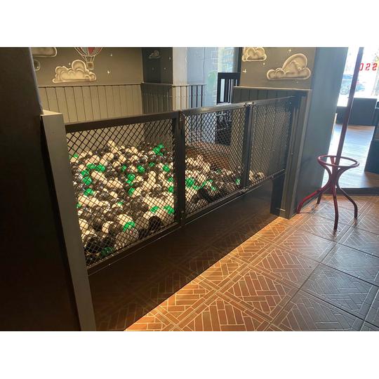 Rosso Joensuun lasten pallomeri, jossa on mustavihreit&auml; ja valkoisia palloja, metalliverkolla suojattuna osana Joen Erikoiskalusteen toteuttamaa leikkitilaa.